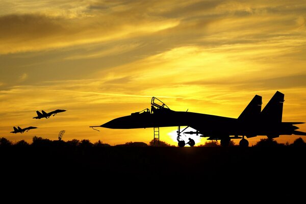 Silhouette of a military aircraft against the background of a beautiful sunset