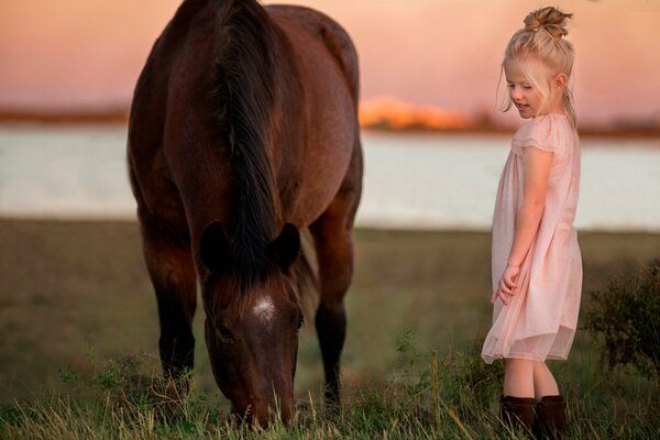 A girl in nature next to a horse