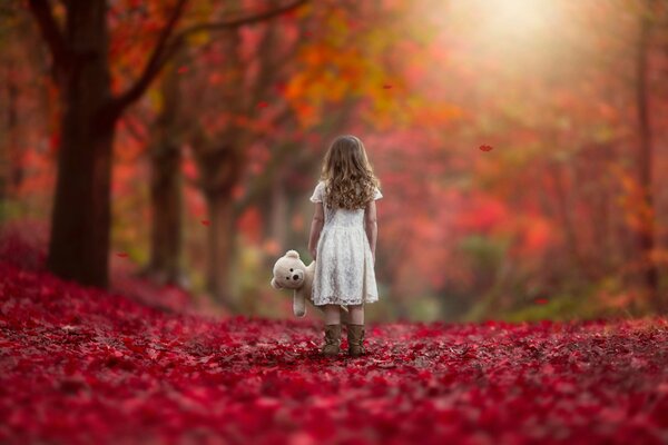 Mädchen mit einem Spielzeug auf einem goldenen Herbst Hintergrund