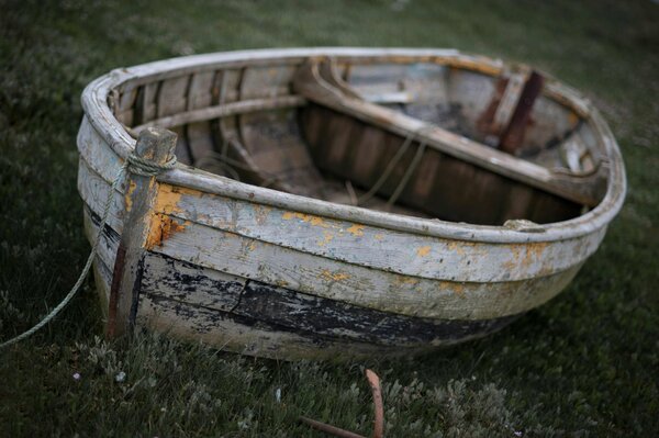 Vieux bateau fané debout sur l herbe verte