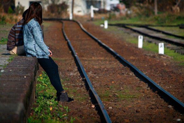 Ragazza in piedi accanto alle rotaie