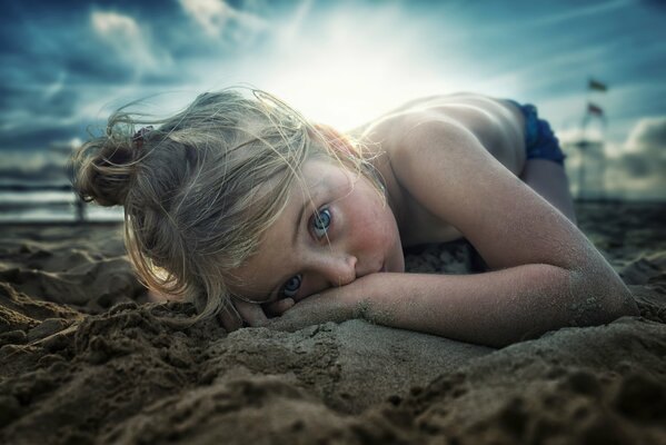 A girl with blue eyes on a sandy beach