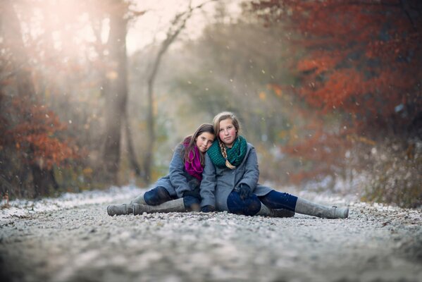 Filles à l automne sur la neige assis sur le côté