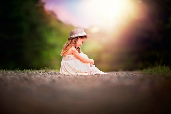 The girl is sitting on her bokeh hat