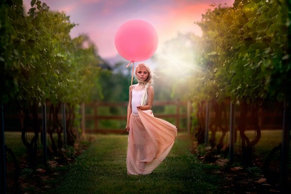 Mädchen mit einem rosa Ball in der Natur