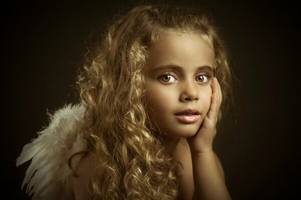 Маленькая девочка ангелочек вопросительно смотрит