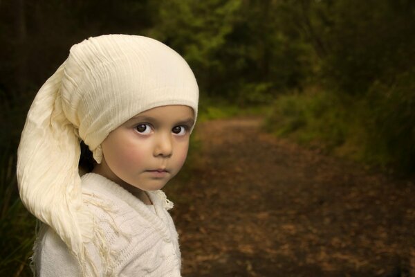 Portrait of a little girl on the background of an autumn forest