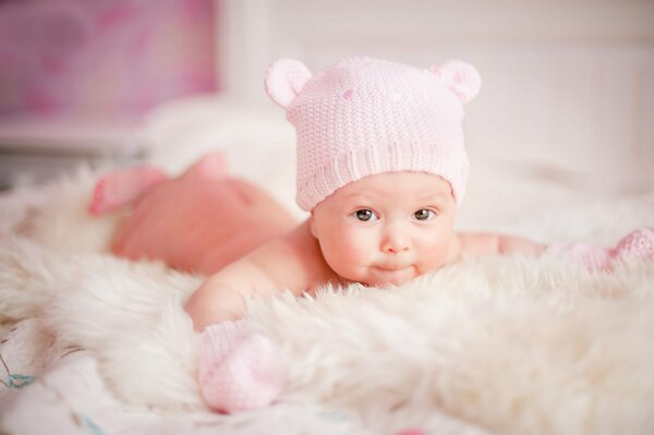 Newborn baby in a knitted suit on the bed