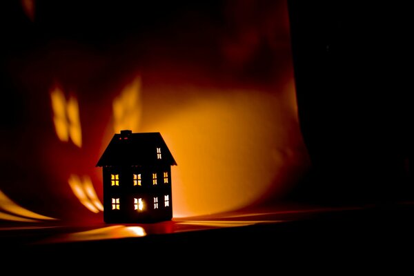 Luz de la casa en la oscuridad con una vela en el interior