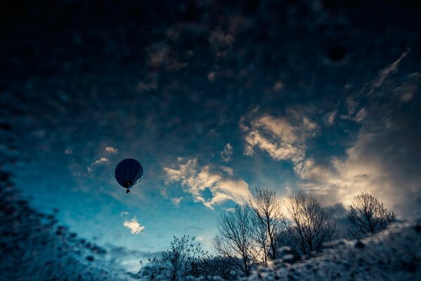 A ball in blue clouds over a shallow forest