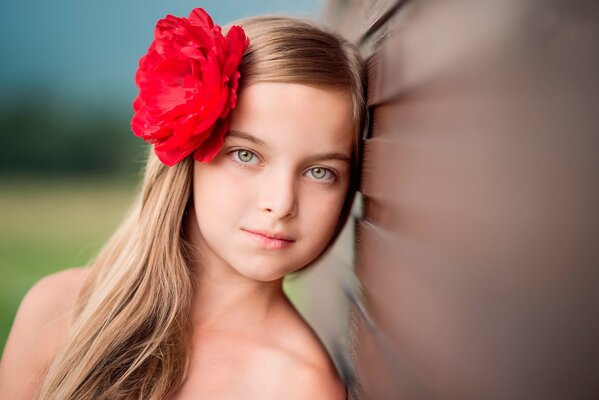 Beautiful blonde girl with a rose in her hair