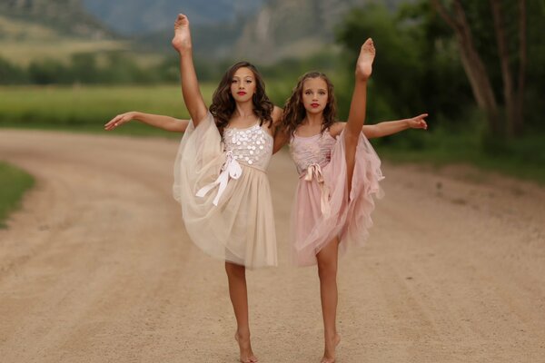 Two dancing girls on the background of nature