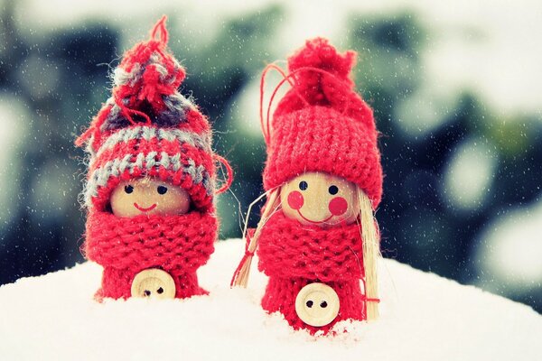 Two red toys in the snow. Macro photography