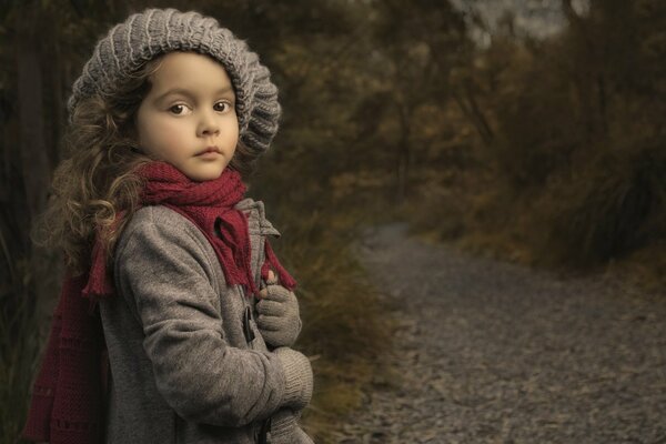 Autumn walk of a girl in a scarf and hat