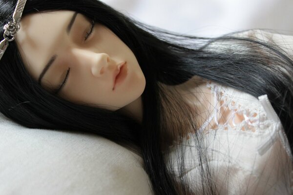 Poupée de fille réaliste dormant dans des pastels