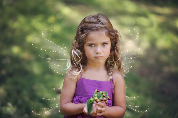 A girl in a lilac dress with wings