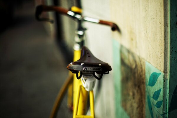 Bicicletta gialla appoggiata al muro