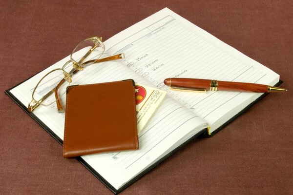 Lunettes, porte-cartes, stylo, carnet de notes en marron