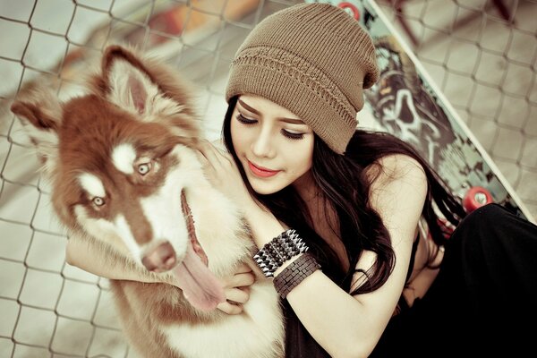 Fille dans un chapeau avec un chien Husky