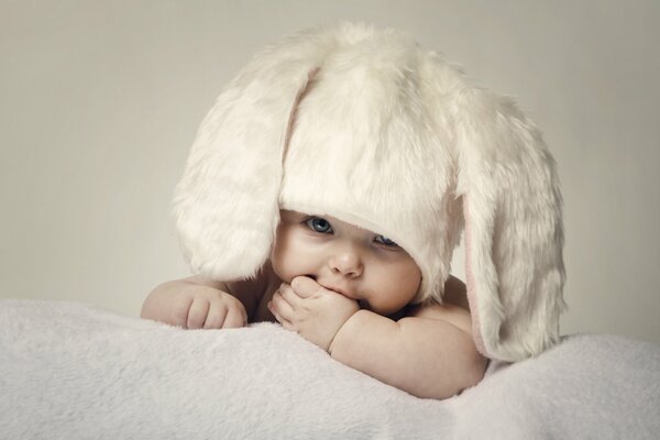 Heureux bébé dans un chapeau de fourrure avec de longues oreilles