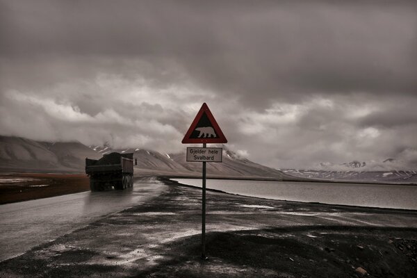 LKW fährt bei Gewitterwetter neben einem Schild