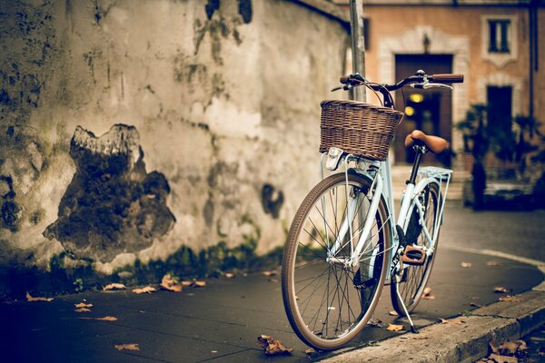 Велосипед на улице у стены дома