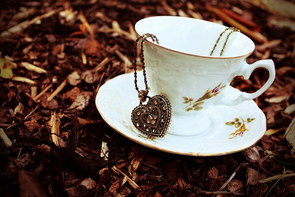 Tasse en porcelaine sur soucoupe avec pendentif