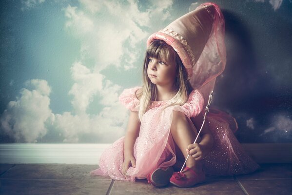 A girl in a fairy costume on a background of wallpaper with clouds