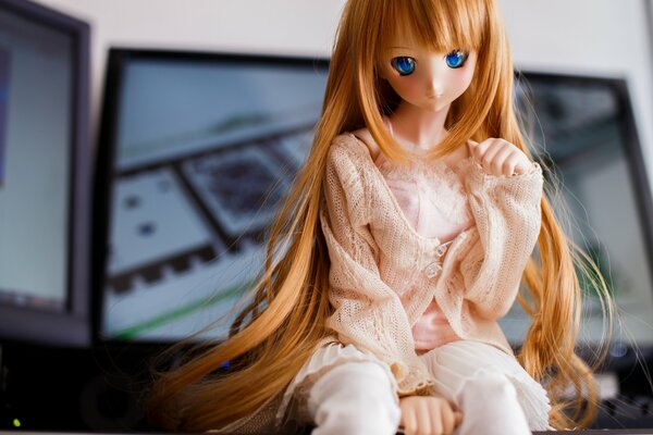 A doll with blue eyes and long hair in a sitting position