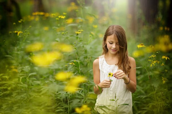 Chica en la naturaleza arrancando flores