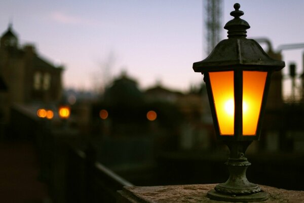 Against the background of the night city - a lonely old lantern