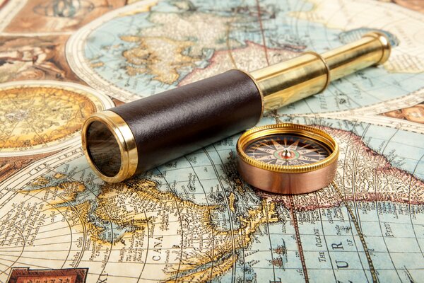 Telescope and compass on the background of a vintage map
