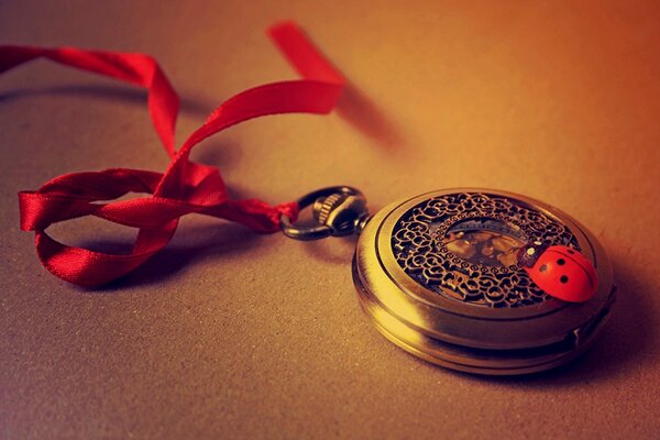 Vintage clock with red ribbon and ladybug