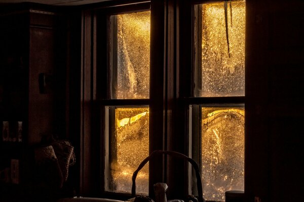 Winterabend und Fenster mit Glas in frostigen Mustern