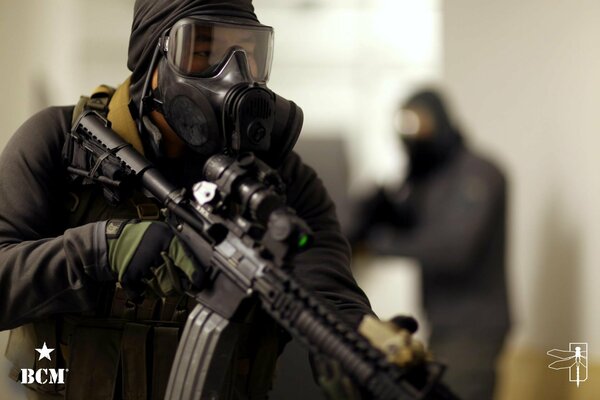 A fighter with an AR-15 in his hands and a gas mask