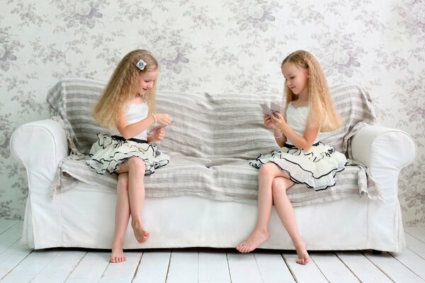 Deux filles jouent sur le canapé dans les cartes