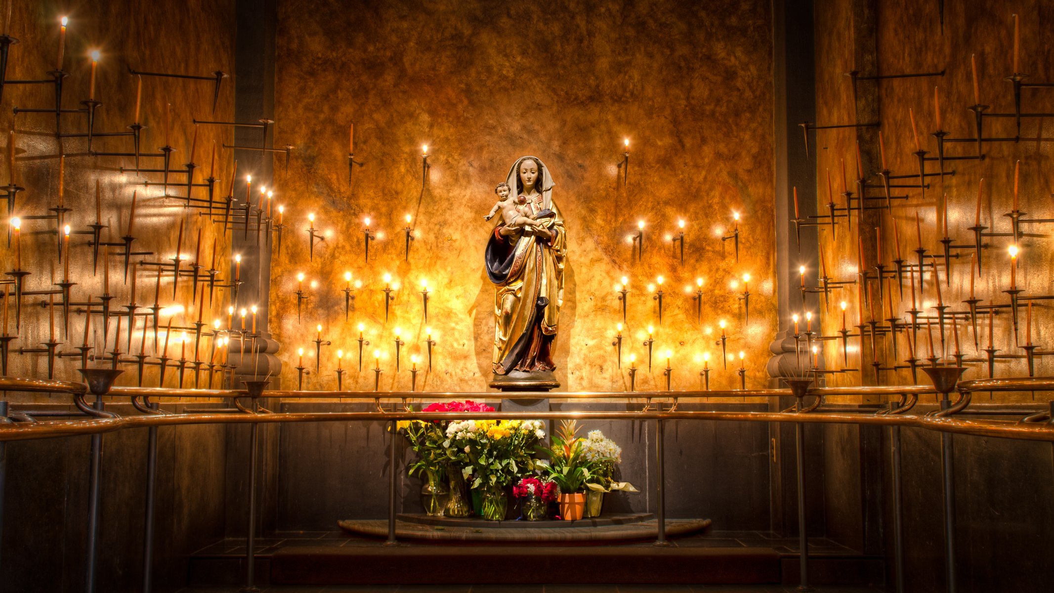 virgen maría estatua velas flores