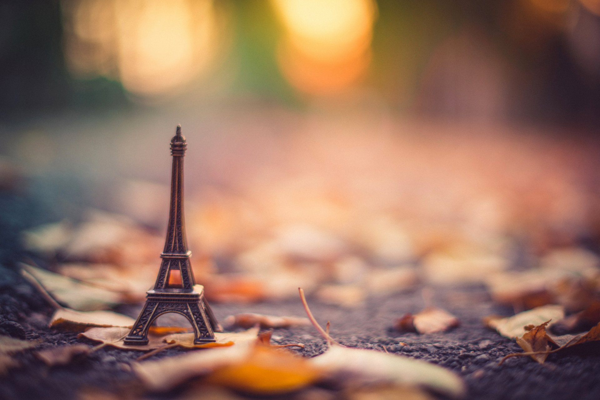 estatuilla soporte la tour eiffel torre eiffel asfalto hojas seco otoño bokeh desenfoque