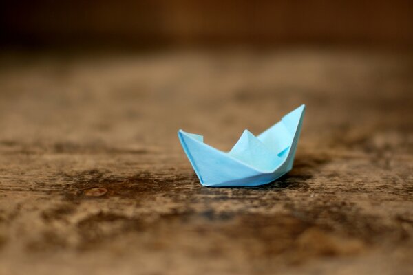 Origami blaues Boot auf Holztisch