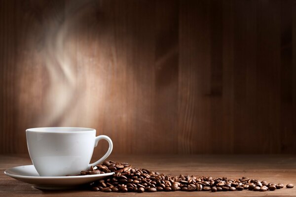 White cup and saucer with scattered coffee beans