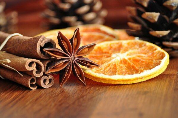 Palitos de canela con un recipiente y naranja seca