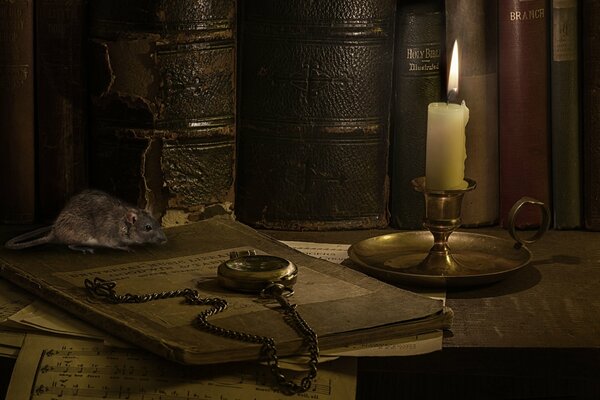 Evening candle on the table with books