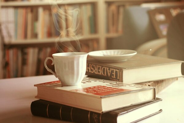 Tè caldo con libri sul tavolo foto luminosa