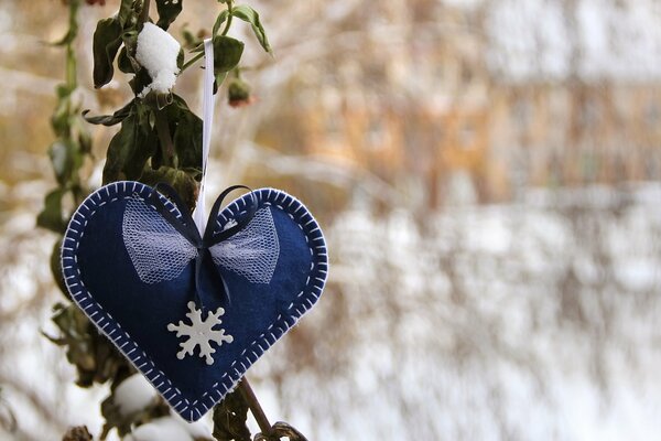 Niebieskie serce z płatkiem śniegu na zimowym tle