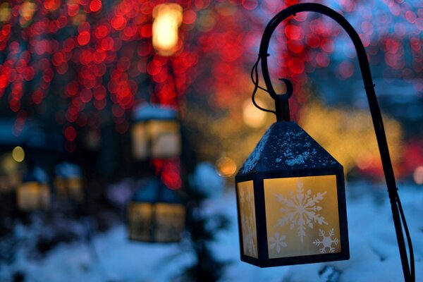 Lanterne con fiocco di neve su sfondo invernale