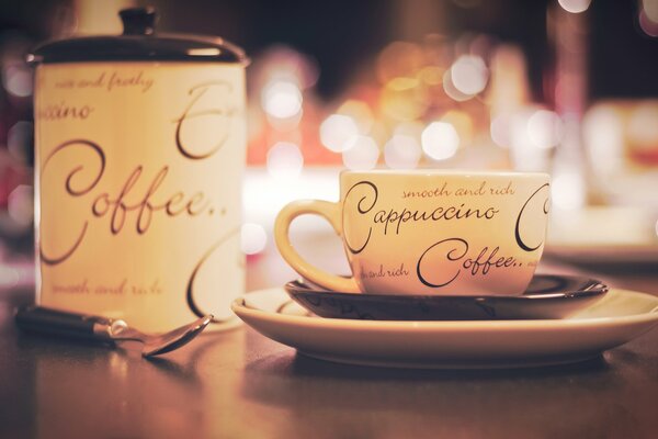 Tasse de cappuccino avec un sucrier sur la table. Photo avec effet bokeh