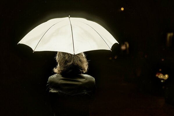 Femme sous un parapluie sur fond sombre