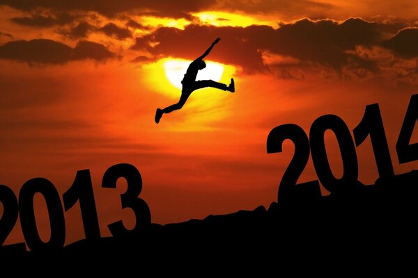 El salto del hombre de 2013 a 2014 en medio de la puesta de sol