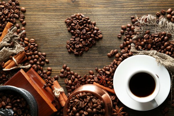 Grains de café en forme de coeur à côté d une tasse de café
