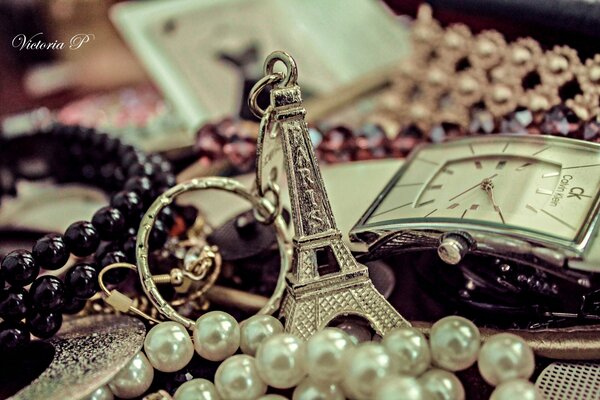 Porte-clés de la tour Eiffel à côté de quelque chose de bijoux et d horloge
